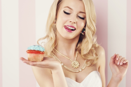 Beautiful blonde woman with blue muffin の写真素材