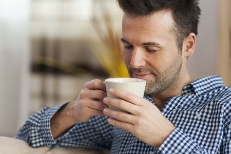 Handsome man tasting morning coffee 
の写真素材