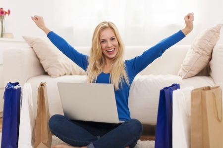Excited young woman with online shopping の写真素材