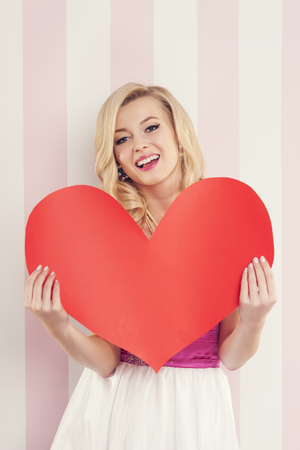 Gorgeous blonde woman with big red heart 
の写真素材