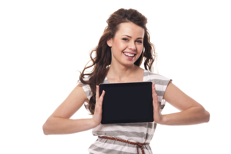 Smiling woman showing screen of digital tablet の写真素材