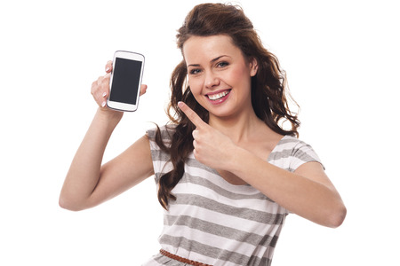 Friendly woman showing on screen white mobile phone の写真素材