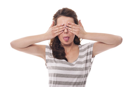 Funny woman covering eyes and sticking out tongueの写真素材