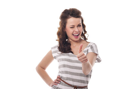 Beautiful woman winking and showing thumbs upの写真素材