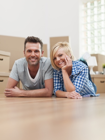 Portrait of happy couple on hardwood floor の写真素材