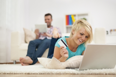 Smiling woman and online shopping at home の写真素材