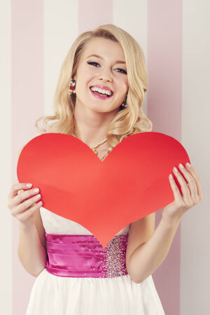 Happy beautiful woman with big red heartの写真素材