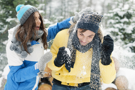 Young couple have fun during the snowball fightの写真素材