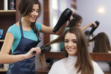 Female hairdresser using hairbrush and hair dryer
の写真素材