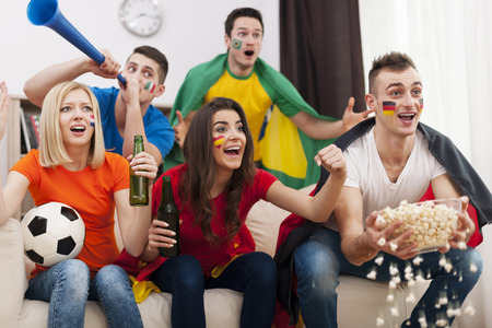 Friends of different nations supporting football team  の写真素材