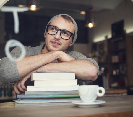 Dreaming nerdy male student in cafe の写真素材