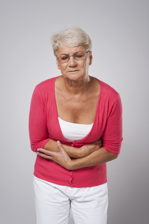 Senior woman suffering from stomach acheの写真素材