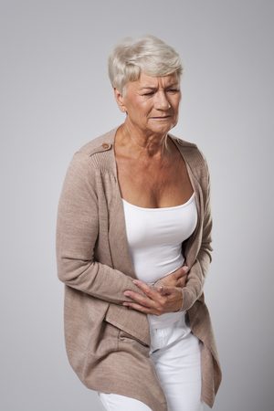 Senior beautiful woman has stomach acheの写真素材