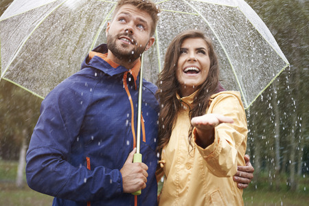 Happy couple during rainの写真素材