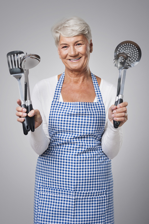 Senior woman with kitchen toolsの写真素材
