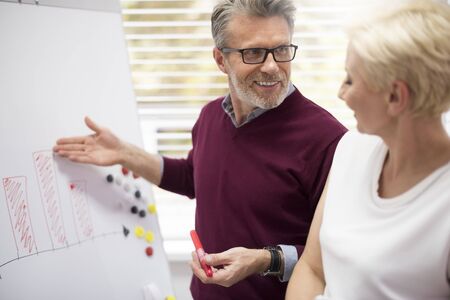 Business partners next to the chart boardの写真素材