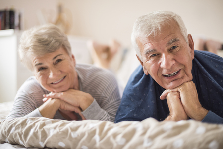 Cheerful senior marriage resting in the bedroomの写真素材