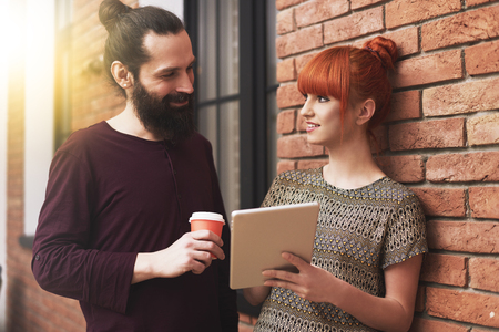 Two young people talking each other at the officeの写真素材