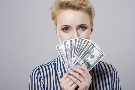 Woman behind a fan of moneyの写真素材