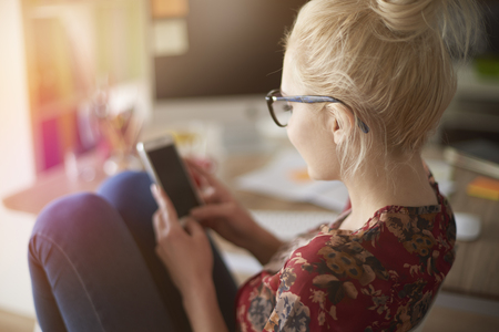 Rear view of woman with mobile phoneの写真素材