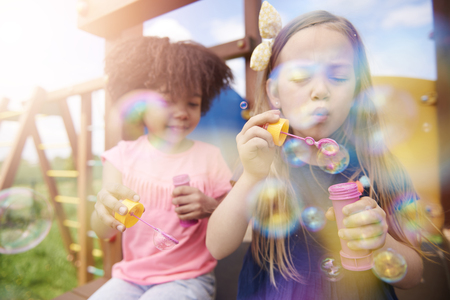 Two cute girls blowing the soap bubblesの写真素材