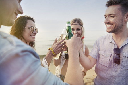 Friends making toast on the beach 