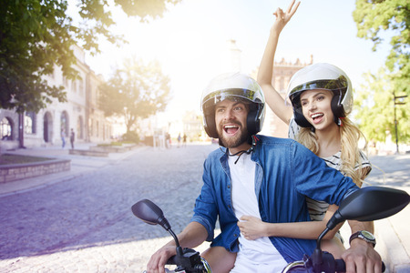 Couple riding a motorbike wearing helmetsの写真素材