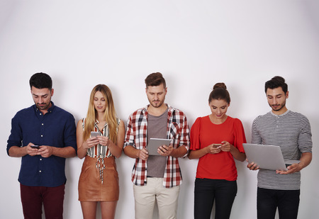 Group of people holding in hand a mobile devicesの写真素材