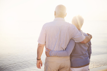 Seniors standing arm by armの写真素材