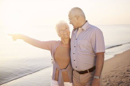 Senior woman with her finger towards the seaの写真素材