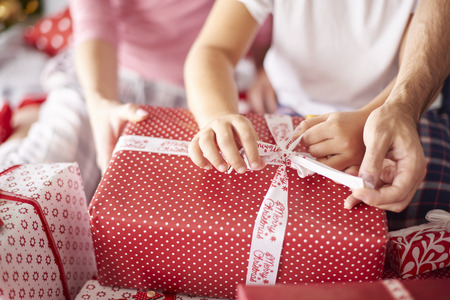 Close up of family hands during opening Christmas presentsの写真素材