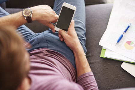 White smart phone in hands of manの写真素材