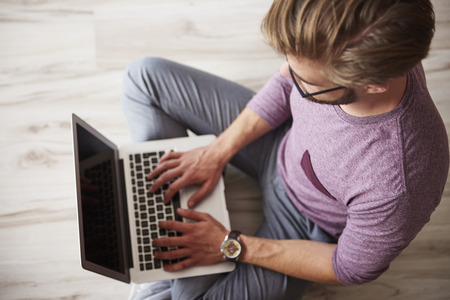 Man using the laptop on the floorの写真素材