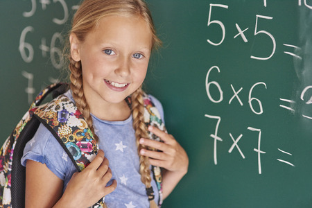Student next to blackboard with numbers