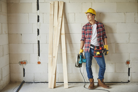 Photography of young carpenter holding jigsawの写真素材
