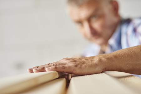 Measuring wooden planks by senior carpenterの写真素材