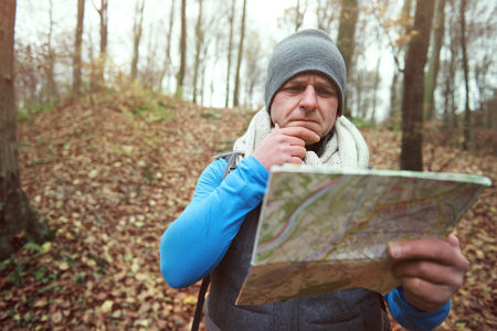Man using paper map in the forestの写真素材