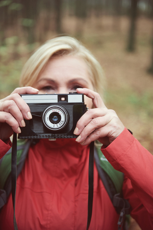 Adult woman taking pictures outdoorsの写真素材