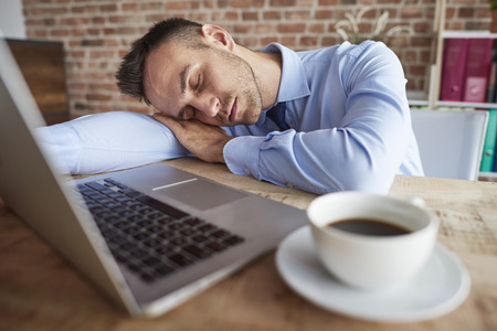 Man sleeping on the office deskの写真素材