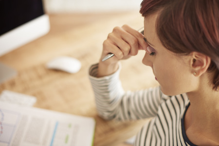 Strong headache during work over documentsの写真素材