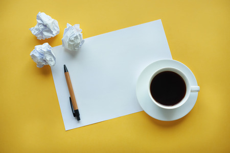 Crumpled up papers on a table by cupの写真素材