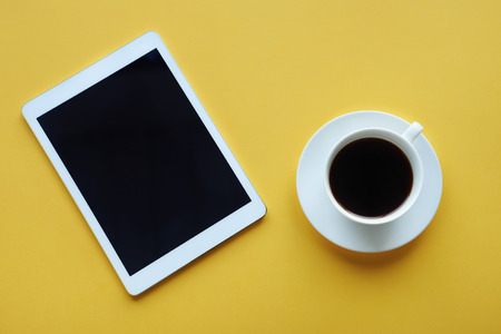 Tablet computer with cup of coffee