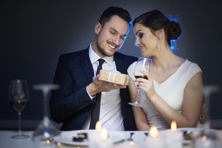 Young couple with present and glass of red wine
の写真素材