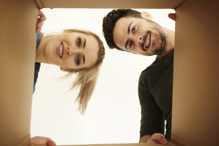 Couple looking down at camera through cardboard box 
の写真素材