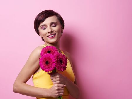 Female beauty smelling flowersの写真素材