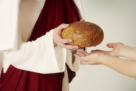 Christs hands handing over loaf of breadの写真素材