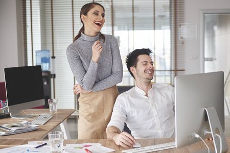 Cheerful coworkers laughing at someones jokeの写真素材