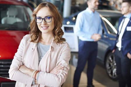 Portrait of confident woman in the car dealershipの写真素材