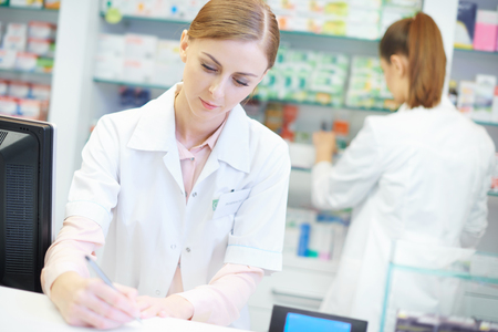 Close up of two busy female pharmacistsの写真素材