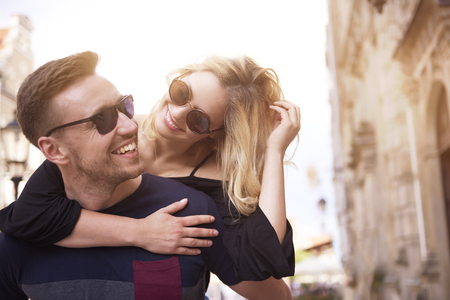 Cheerful man carrying his beloved girlの写真素材